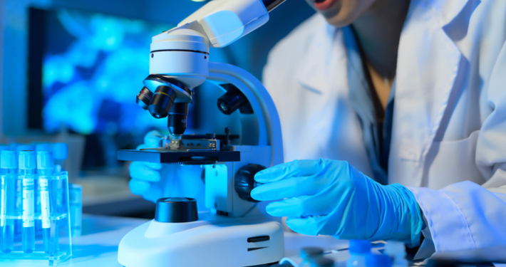 closeup of a scientist looking in a microscope, life science commercial real estate